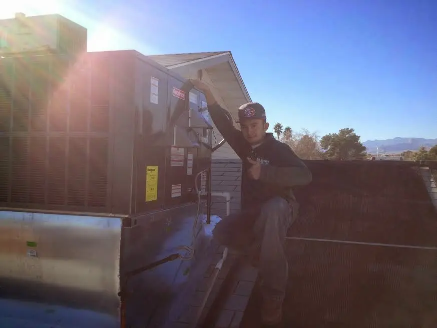 HVAC technician performing Boiler Repair on a rooftop unit in Blackfoot
